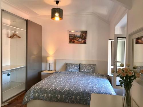 een slaapkamer met een bed en een vaas met bloemen bij Luciano Resident in Lissabon