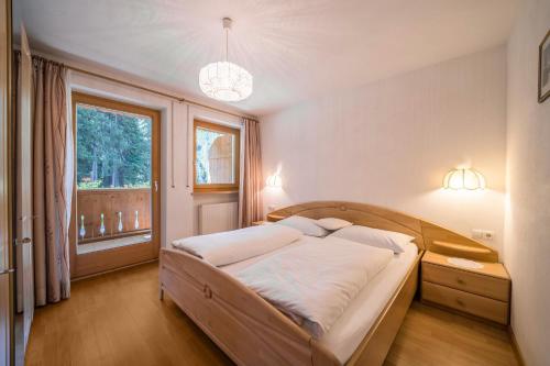 Un dormitorio con una cama grande y una ventana en Ferienhaus Maria Steinröserl, en Pfelders