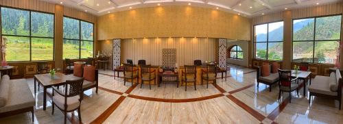 a large room with tables and chairs and windows at The Sultan Resort in Kulan