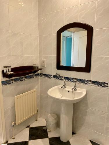 a bathroom with a sink and a mirror at Twin Trees Hotel & Leisure Club in Ballina