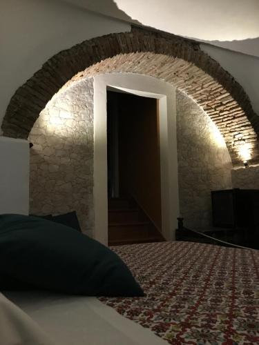a bedroom with a bed and a stone wall at Original Sicily in Santa Venerina
