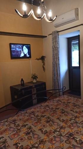 a bedroom with a bed and a tv on the wall at Original Sicily in Santa Venerina
