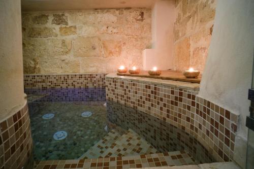 een badkamer met een bad met kaarsen bij Al Chiasso 12 in Monopoli