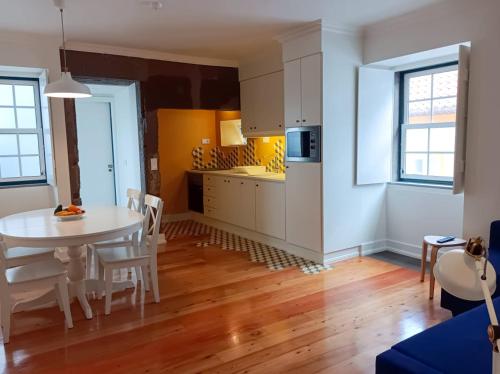 a kitchen and dining room with a table and chairs at Apartamentos Ázera - Laura Ázera in Praia da Vitória