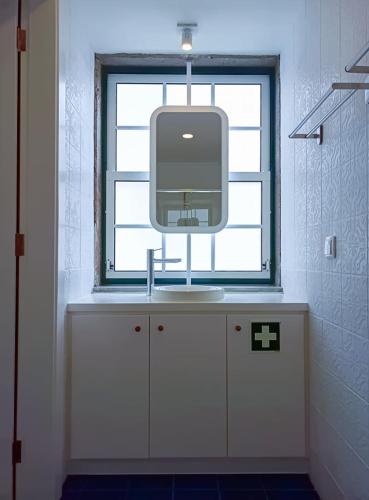 a tv sitting on a counter in a bathroom with a window at Apartamentos Ázera - Laura Ázera in Praia da Vitória