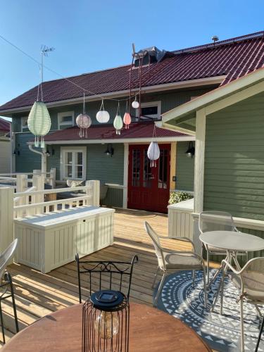 a deck with a table and chairs on a house at Eleonora Bed & Breakfast in Kristiinankaupunki