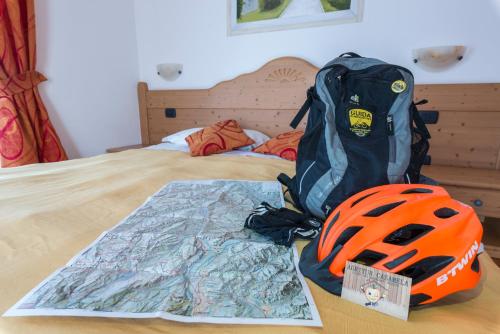 a backpack and a helmet sitting on top of a bed at Agritur Casamela in Taio