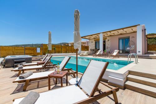 a villa with a swimming pool and lounge chairs at Kallixeni Villas in Rethymno Town