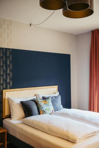 a bedroom with a bed with a blue wall at Appartementhotel am Weissensee in Weissensee