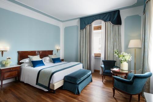 a bedroom with a large bed and blue walls at Bettoja Hotel Mediterraneo in Rome