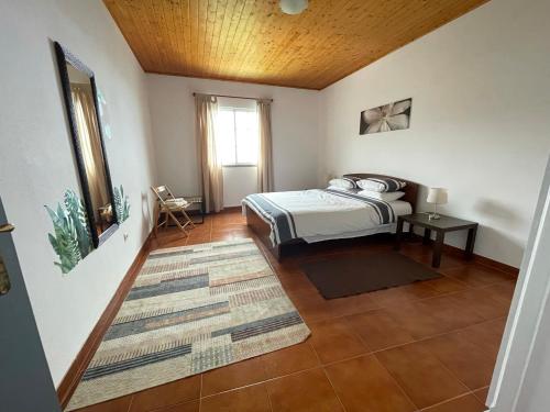 sypialnia z łóżkiem i drewnianym sufitem w obiekcie Casa Vista do Ledo w mieście Arco da Calheta