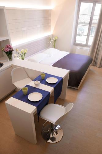 a room with a bed and a blue table and chairs at Palazzo dei Ciompi Suites in Florence