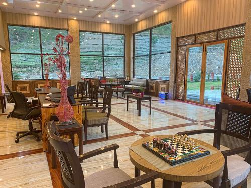 un restaurante con mesas y sillas y un tablero de ajedrez sobre una mesa en The Sultan Resort, en Kulan