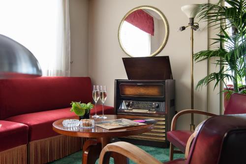 a living room with a red couch and a table at Bettoja Hotel Mediterraneo in Rome