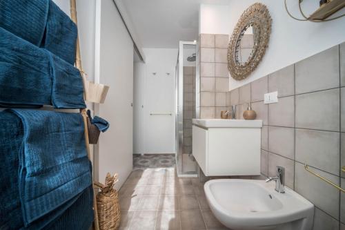 a bathroom with a sink and a toilet and a mirror at Casa Royale Appartamento Terra in Lierna