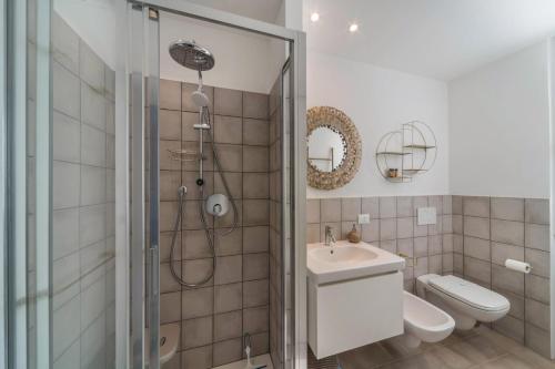 a bathroom with a shower and a toilet and a sink at Casa Royale Appartamento Terra in Lierna