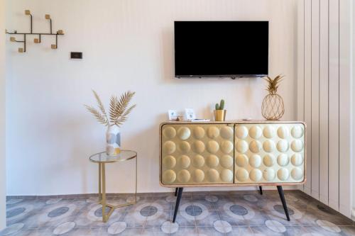 a living room with a couch and a tv on a wall at Casa Royale Appartamento Terra in Lierna