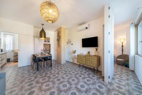 a living room with a table and a television at Casa Royale Appartamento Terra in Lierna