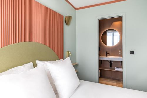 a bedroom with a bed with a mirror and a sink at O.Lysée Hotel in Paris