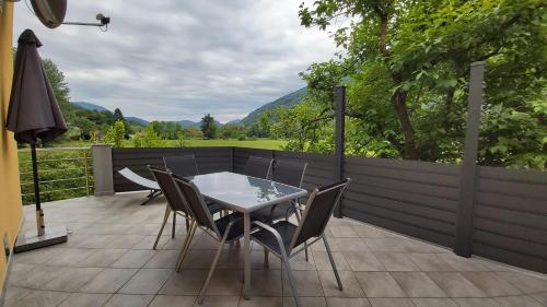 a patio with a table and chairs and a fence at Emerald Soca Apartment in Tolmin