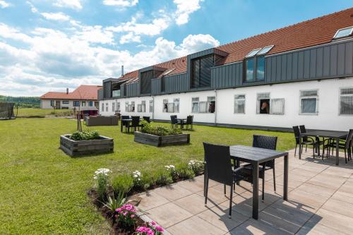 eine Terrasse mit Tischen und Stühlen im Garten in der Unterkunft Bílichov in Bílichov