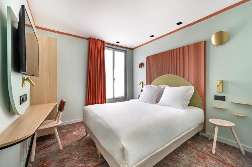 a hotel room with a bed and a tv at O.Lysée Hotel in Paris