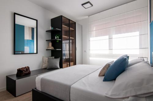 una camera da letto con un grande letto bianco con cuscini blu di Casa Scalzi a Roma