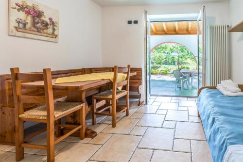 a dining room with a table and chairs and a bed at Agritur Casamela in Taio