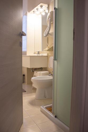 a bathroom with a white toilet and a sink at Hotel Dolomiti in Malcesine