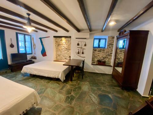a room with two beds and a table in it at SAIL house in Skala Kallirakhis