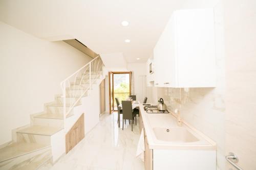 斯卡拉的住宿－La Piazzetta Boutique Apartments，白色的厨房设有水槽和楼梯