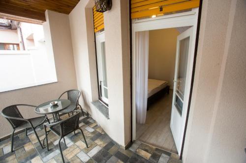 a room with a table and chairs and a room with a bed at Central 10 in Oradea