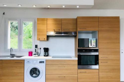 une cuisine avec des armoires en bois et un four à plaques de cuisson dans l'établissement Bel appartement dans villa à la campagne proche d’Ajaccio, à Poggi