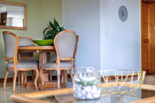 a dining room with a table with chairs and a mirror at Alcazar de Oviedo by EE Hoteles in Medellín