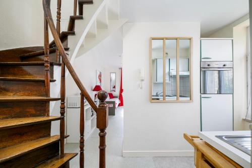 - un escalier dans un salon aux murs blancs dans l'établissement Résidence du Prieuré, à Dinard