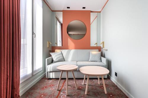 a living room with a couch and two tables at O.Lysée Hotel in Paris