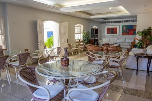 a room with tables and chairs and a living room at Pousada Boulevard in Cabo Frio