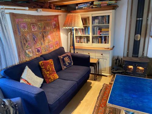 a living room with a blue couch and a fireplace at Airebroc Byre in Uig