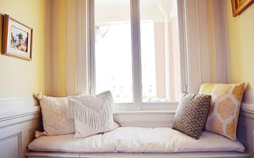 a window seat in front of a window with pillows at JH Adams Inn, Trademark Collection by Wyndham in High Point