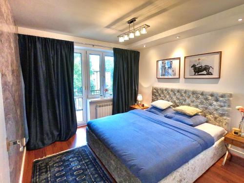 グディニャにある"Cambiani Royal" luksusowy apartament blisko morzaのベッドルーム(大型ブルーベッド1台、窓付)