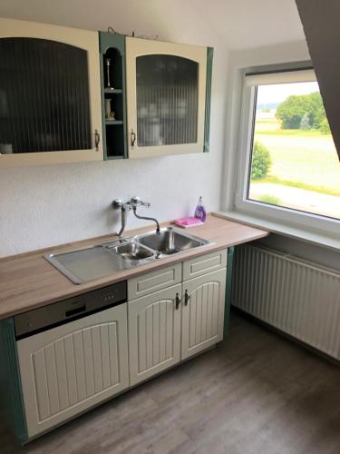 uma cozinha com um lavatório e uma janela em Ferienwohnung an der A7 em Northeim