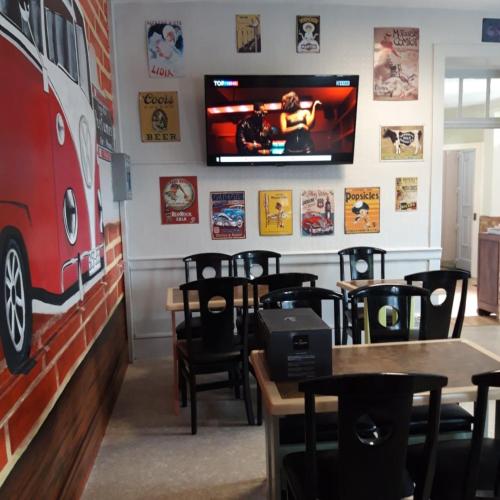 a restaurant with tables and a tv on the wall at Chambres d'hotes Condat in Condat-sur-Ganaveix