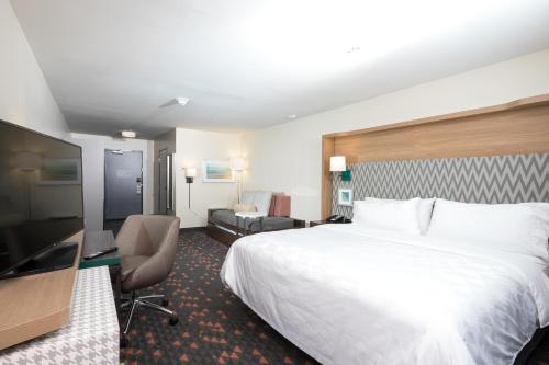 a hotel room with a bed and a desk at Holiday Inn Hotel & Suites - Mount Pleasant by IHG in Mount Pleasant