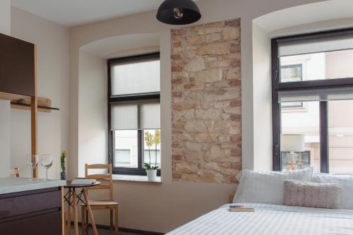a bedroom with a bed and a stone wall at Pod Jasną 28 in Częstochowa
