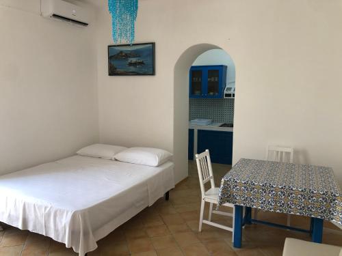 a bedroom with a bed and a table with a chair at Il Cortiletto - Lipari CENTRO in Lipari