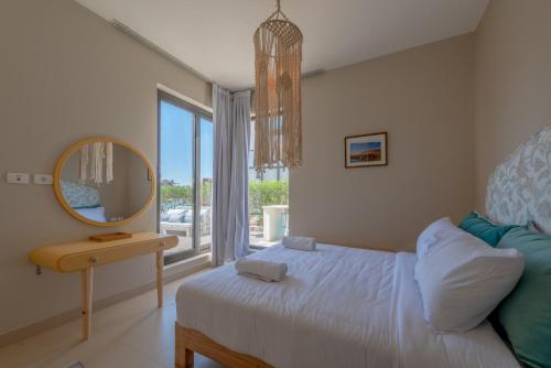 1 dormitorio con cama, espejo y ventana en La Casa de Playa Tawila on Island 4BR Private with Heated Pool en Hurghada
