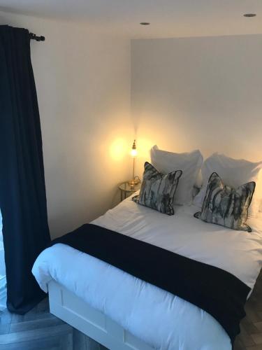 a bedroom with a white bed with two pillows at Unique Belfast Stay in Belfast
