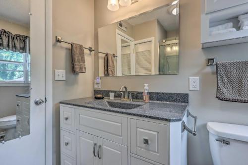 a bathroom with a sink and a mirror at Cheerful Camdenton Cottage Steps to Lake! in Camdenton