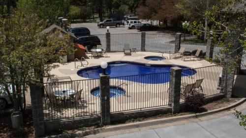 an iron fence around a pool with chairs and tables at Comfort Inn Flagstaff South I-17 in Flagstaff