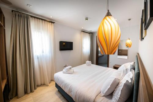 a bedroom with a large bed with white sheets at Bliss Boutique Living in Xagħra